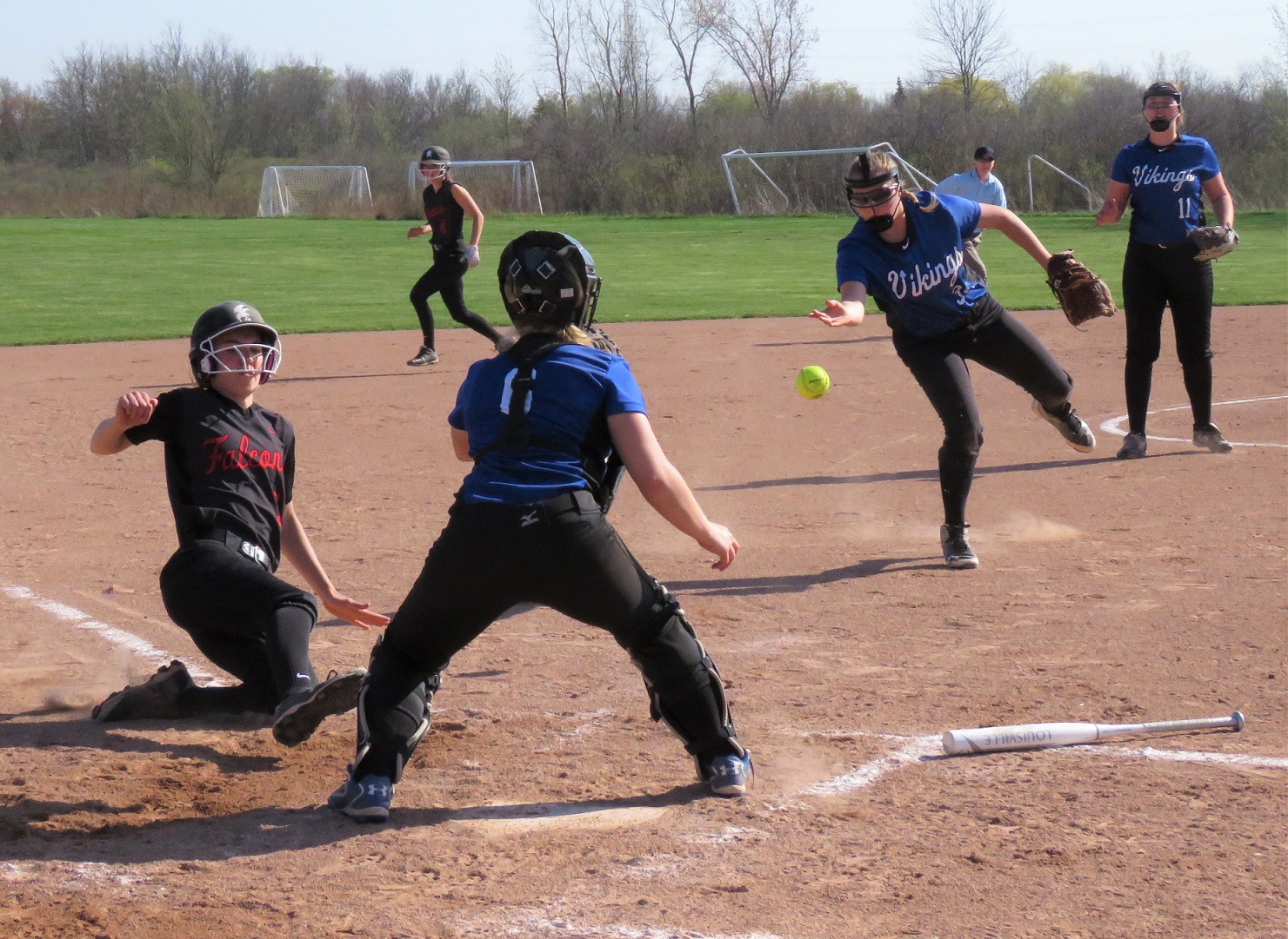 Carly Milleville slides into home plate safely after a squeeze bunt by Sydney Crangle, dodging the tag of Grand Island catcher Shay Sommer. (Photo by David Yarger)
